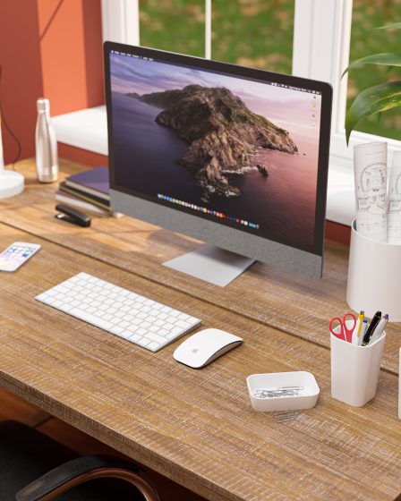 Uma escrivaninha marrom com um Macbook e alguns porta-objetos da linha Office da Astra aparecem na imagem.