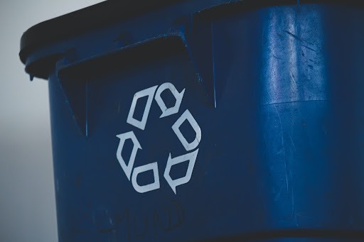 Uma lixeira azul com o símbolo de reciclagem, que representa como separar o lixo.
