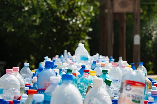 Várias garrafas de plástico amontoadas ao ar livre.