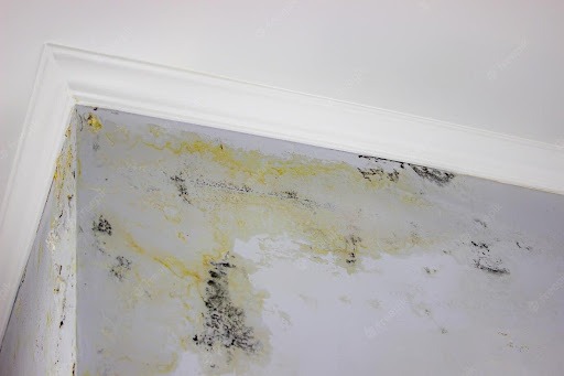 Na imagem temos uma parede branca com manchas amarelas, muito provavelmente, devido a uma infiltração.