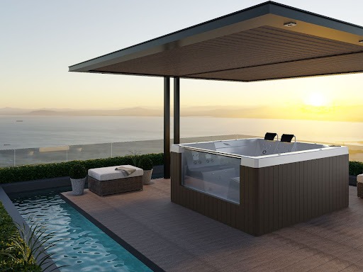 Na imagem acima possui um deck com uma SPA Astra e uma piscina à esquerda. Ao fundo está o pôr do sol com vista para o mar. 